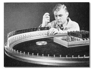 technician is seen bolting a glass-mounted 35mm slide onto one of eleven large drums that were required to hold the 2,112 slides 